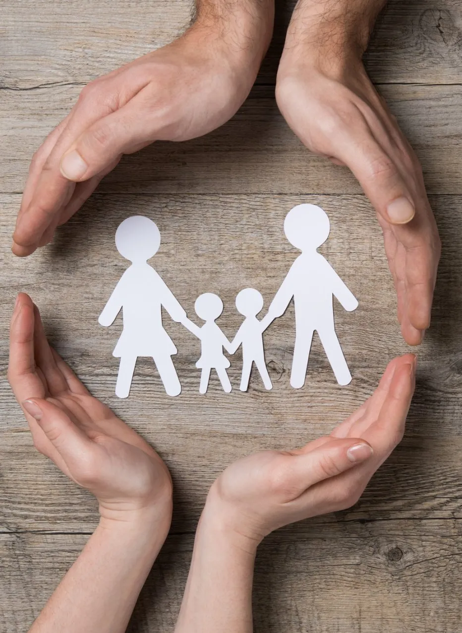four hands circling a paper Scissor family.